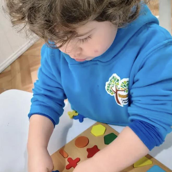 Niño trabajando con material Montessori de encaje