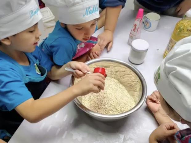 Niños con gorro de chef preparando una receta